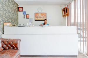 a woman sitting at a counter in a room at Roomquet comfort in Prayagraj