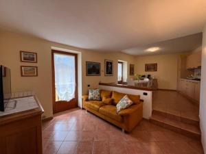 a living room with a couch and a kitchen at Panoramic View Ledro Apartment in Mezzolago