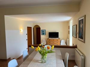 a vase of flowers on a table in a living room at Panoramic View Ledro Apartment in Mezzolago