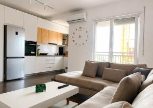 a living room with a couch and a table at Romantic Penthouse with Mountains View in Kashari
