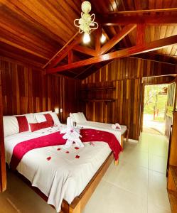 two beds in a room with wooden walls at Pousada da Cachoeira in Monte Alegre do Sul +31 photos