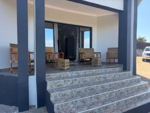 a set of stairs leading to a porch with chairs at Hilltop Villa Sengabay in Salima