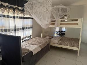 two bunk beds in a room with curtains at Hilltop Villa Sengabay in Salima