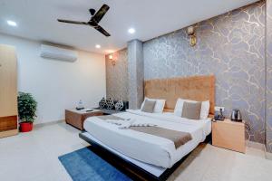 a bedroom with a large bed and a wall at Roomquet comfort in Prayagraj +46 photos