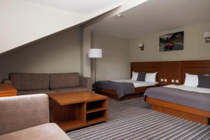 a hotel room with two beds and a couch at Hotel 4x4 in Rivne