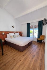 a bedroom with a large bed and a wooden floor at L'auberge Camarguaise in Saintes-Maries-de-la-Mer +69 photos