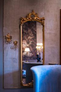a large mirror in a room with a blue chair at Hotel Heureka in Venice