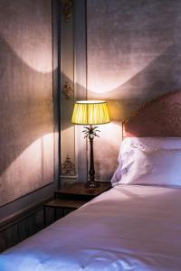 a bedroom with a bed and a lamp on a table at Hotel Heureka in Venice