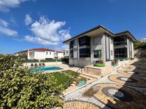 a house with a swimming pool next to a building at Easy Stay Mia Suites in Aydın