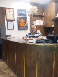 a man sitting at a bar in a restaurant at Hotel Atithi Palace in Jabalpur