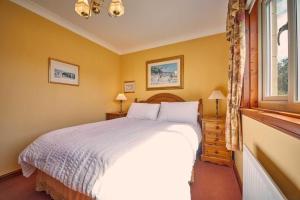 a bedroom with a white bed and a window at Host & Stay - Cheviot View in Seahouses +10 photos