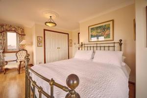 a bedroom with a large bed and a chair at Host & Stay - Cheviot View in Seahouses