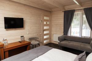 a bedroom with a bed and a desk and a television at Hotel 4x4 in Rivne