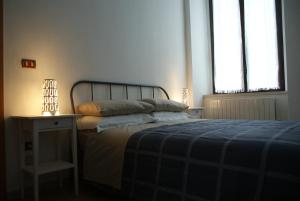 una camera da letto con un letto con una coperta blu e due finestre di Casa Elisa a Cosenza