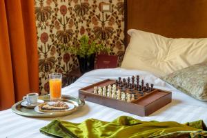 a chess board on a bed with a tray of food at Hotel Parrasio in Rome