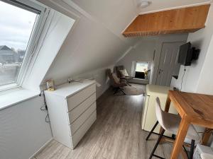 a small attic room with a desk and a window at Waterzicht 3 in Uitwellingerga +5 photos