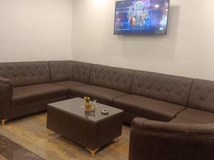 a living room with a brown couch and a table at Hotel Atithi Palace in Jabalpur