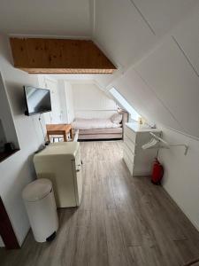 a attic room with a bed and a desk at Waterzicht 3 in Uitwellingerga