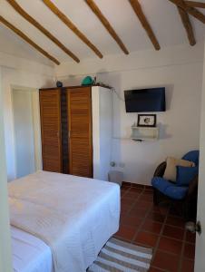 a bedroom with a bed and a blue chair at Casa Brisa Marina El Yaque in El Yaque