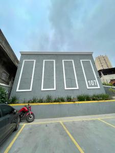 a motorcycle parked in a parking lot in front of a sign at Studio 107 in São Paulo