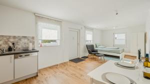 a white kitchen and living room with a couch at Apartment am Fuchseck in Schorndorf