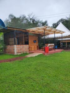 a pavilion with benches and tables in a yard at Darajani Motel in Sanya Juu