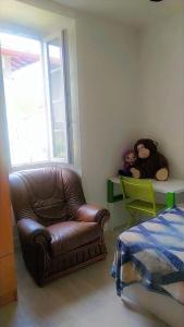 a living room with a leather chair and teddy bears on a table at Hasparren in Hasparren