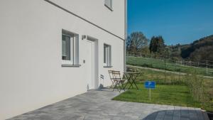 a white house with a table and chairs on a patio at Apartment am Fuchseck in Schorndorf