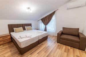 a bedroom with a bed and a chair at Smokinite Villa 1 - Pool and BBQ near the beach in Varna City