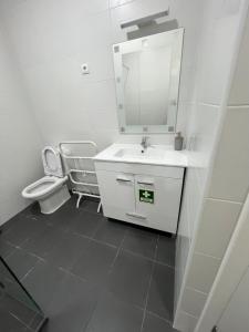 a white bathroom with a sink and a toilet at O Prior - Aposentos in Urzelina +12 photos
