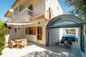 a house with a patio with a table and a pool at Casa dos mares in San Javier