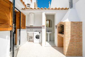 a white bathroom with a washer and dryer at Casa dos mares in San Javier