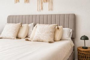 a bed with white pillows and a gray headboard at Casa dos mares in San Javier +23 photos