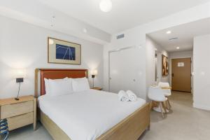 a bedroom with a large bed with white sheets at Downtown Studio Steps from Kaseya Center in Miami