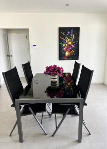 a dining room table with chairs and a vase of flowers at Casa Trankilo in Fontein