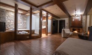 a bedroom with a bed and a fireplace at Nymfes Hotel in Kato Loutraki +46 photos