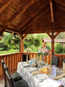 a table on a wooden deck with a table set for dinner at Complex Turistic Suatu in Suatul
