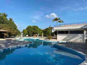 a swimming pool with blue water in a resort at Chalé Gravatá in Gravatá