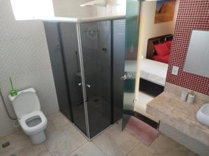 a bathroom with a shower with a toilet and a sink at Pousada Consulado in Brasília +35 photos