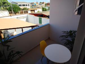 a small balcony with a white table and a yellow chair at Pousada Consulado in Brasília