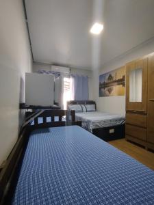 a room with two beds and a dresser and a bed sidx sidx sidx sidx at Pousada Consulado in Brasília