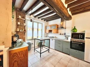 a kitchen with a table in the middle of it at Baolocation Bouhy - Idéal famille & groupe d'amis -16min Guédelon - Wifi in Bouhy +54 photos
