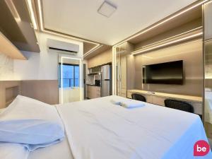 a large white bed in a room with a tv at Beach Class Meireles in Fortaleza +50 photos