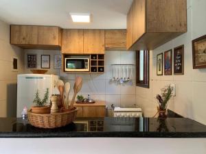 a kitchen with wooden cabinets and a counter top at Chalé Gravatá in Gravatá