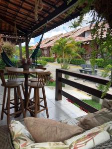 a patio with a hammock and a table and chairs at Chalé Gravatá in Gravatá