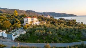 a house on a hill next to the water at Lumaverde Estate in Kalamata