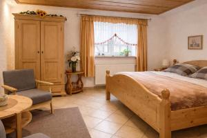 a bedroom with a bed and a chair and a window at Gasthof und Eiscafe Frank in Leimbach