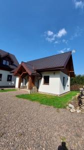 a white house with a brown roof at Domek u Hillów in Stronie Śląskie