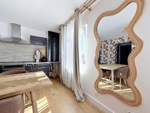 a dining room with a large mirror on the wall at Appartement Imalia Prestige et Elegance in Bray-Dunes