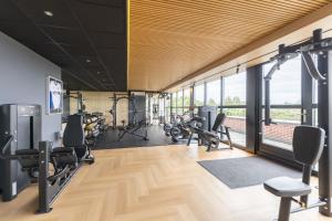 a gym with treadmills and exercise equipment in a building at Hotel Asteria in Venray